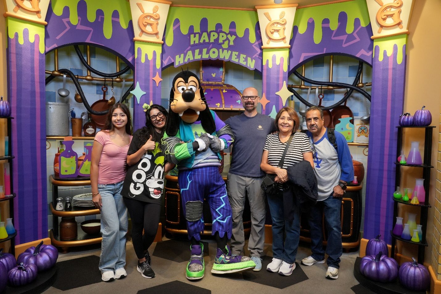 Family posing with Goofy at Goofy’s Kitchen.
