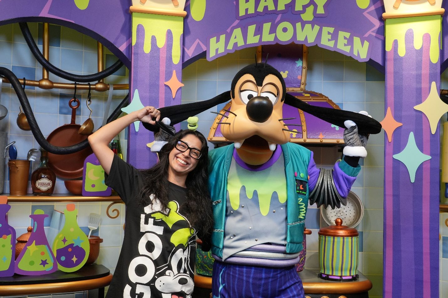 Goofy posing with family at a Halloween-themed backdrop.