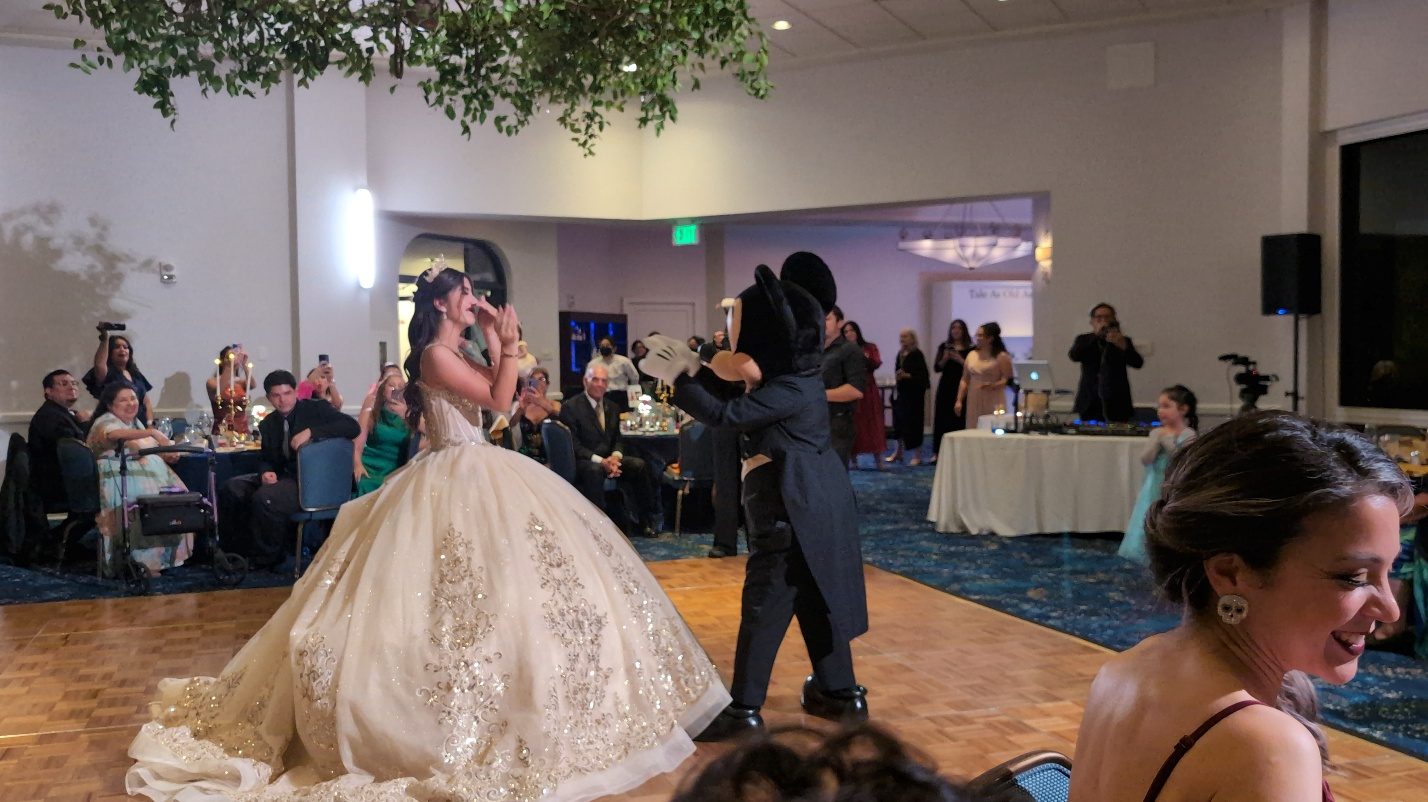 Quinceañera dancing as guests watch.