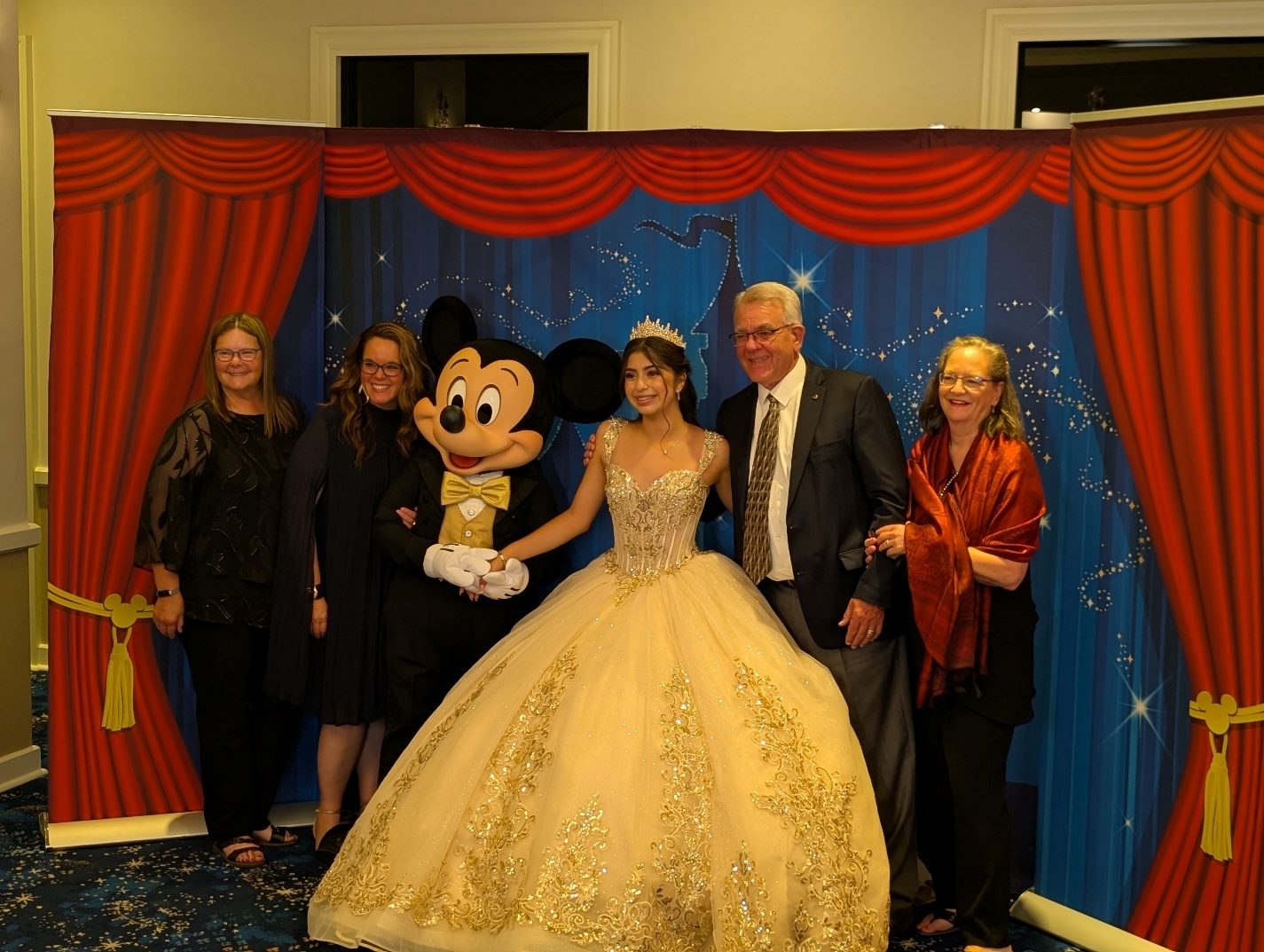 Family group photo with Mickey Mouse at the quinceañera party.