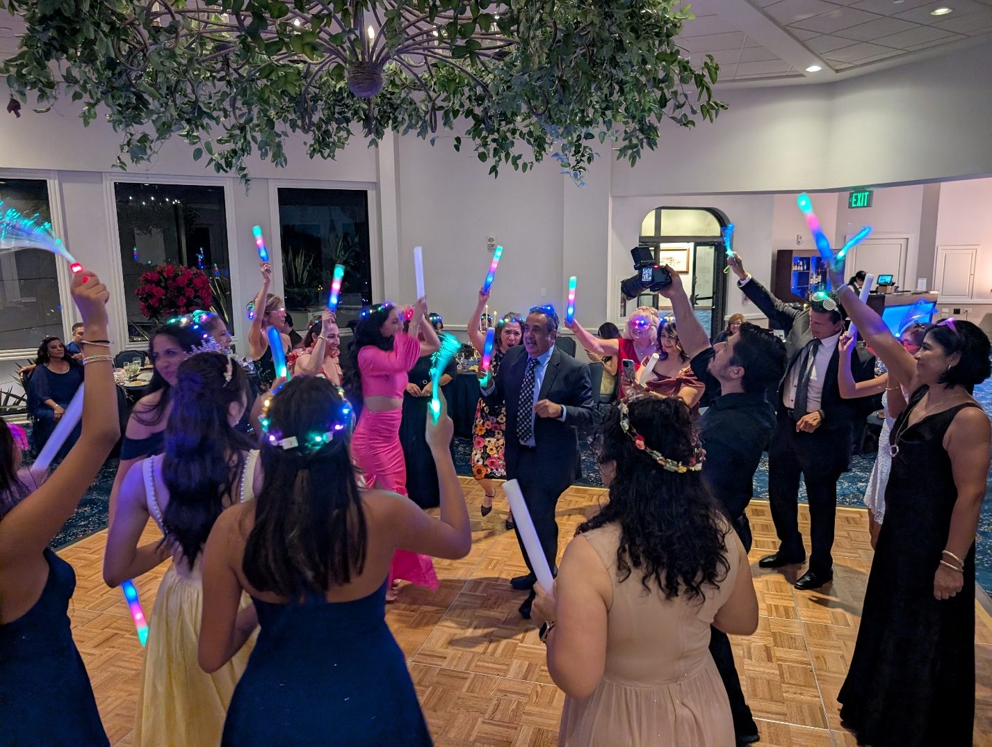 Guests dancing with glow sticks at the party.
