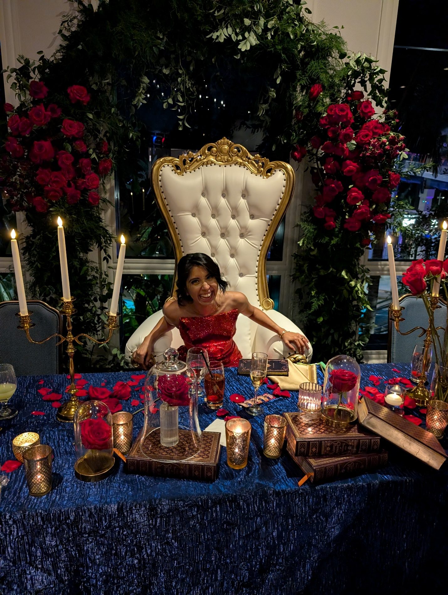 Quinceañera laughing while seated at the main table.