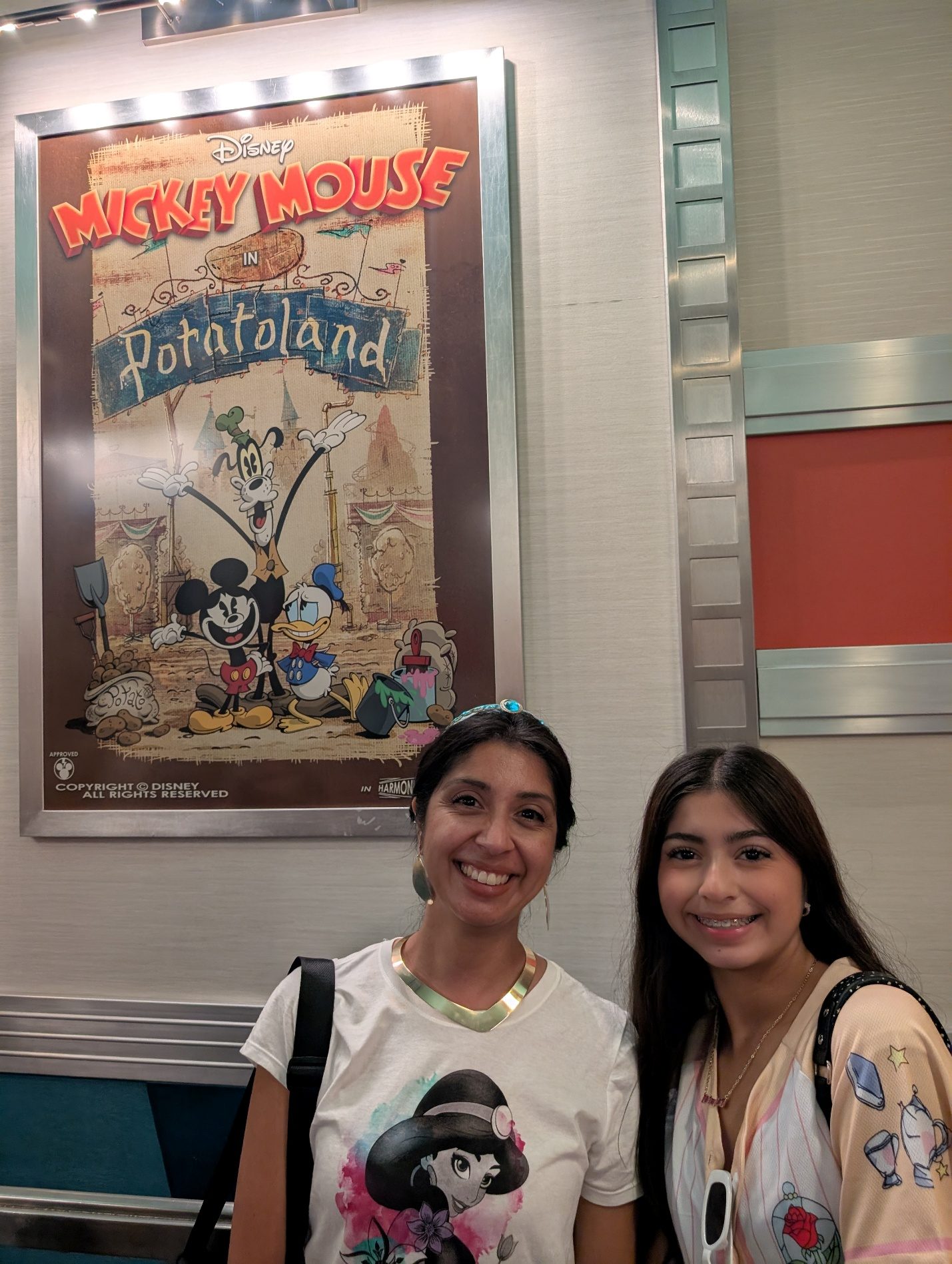 Guests posing by a Mickey and Minnie poster.