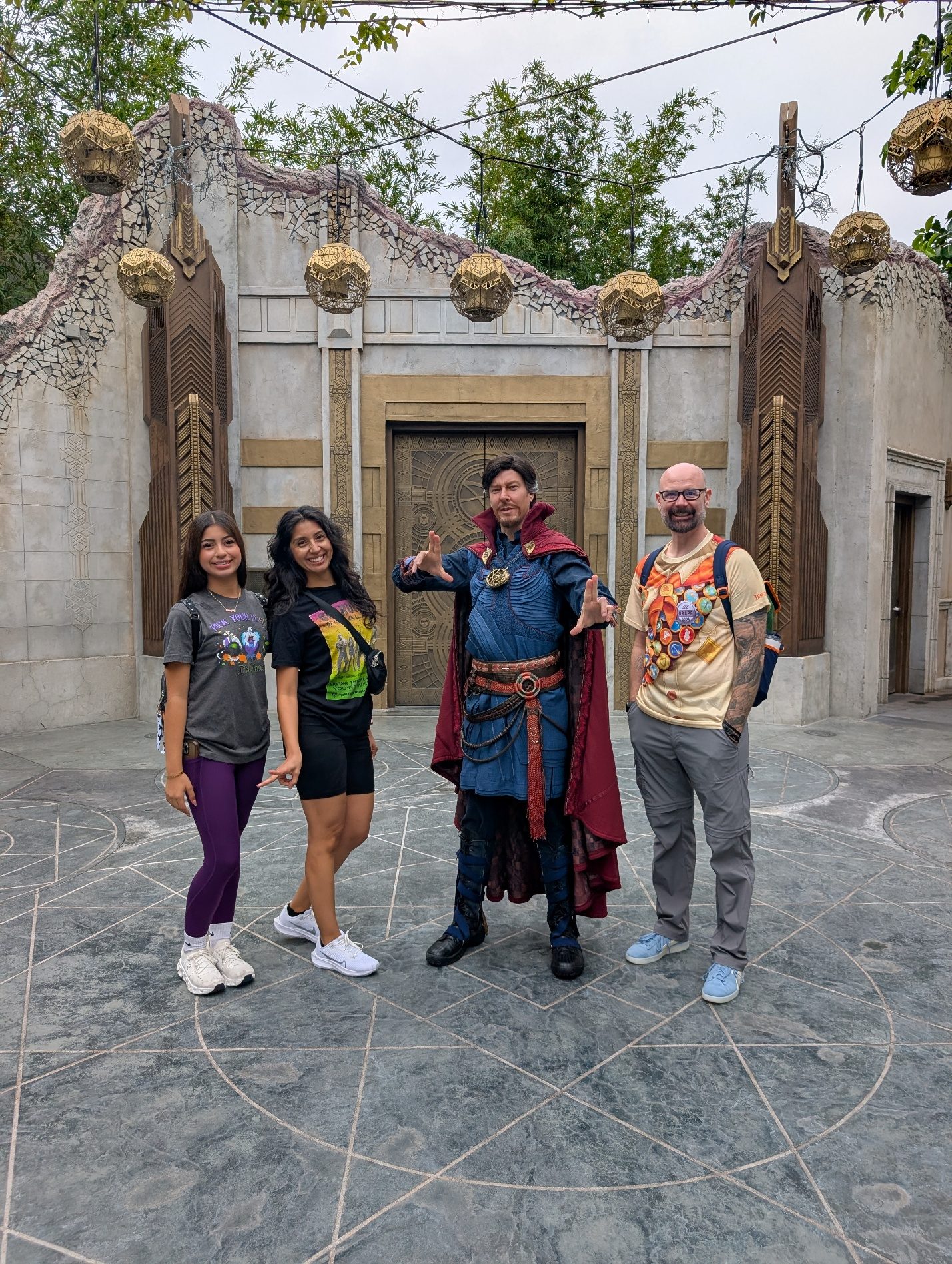 Family posing near a stone doorway in Avengers Campus.