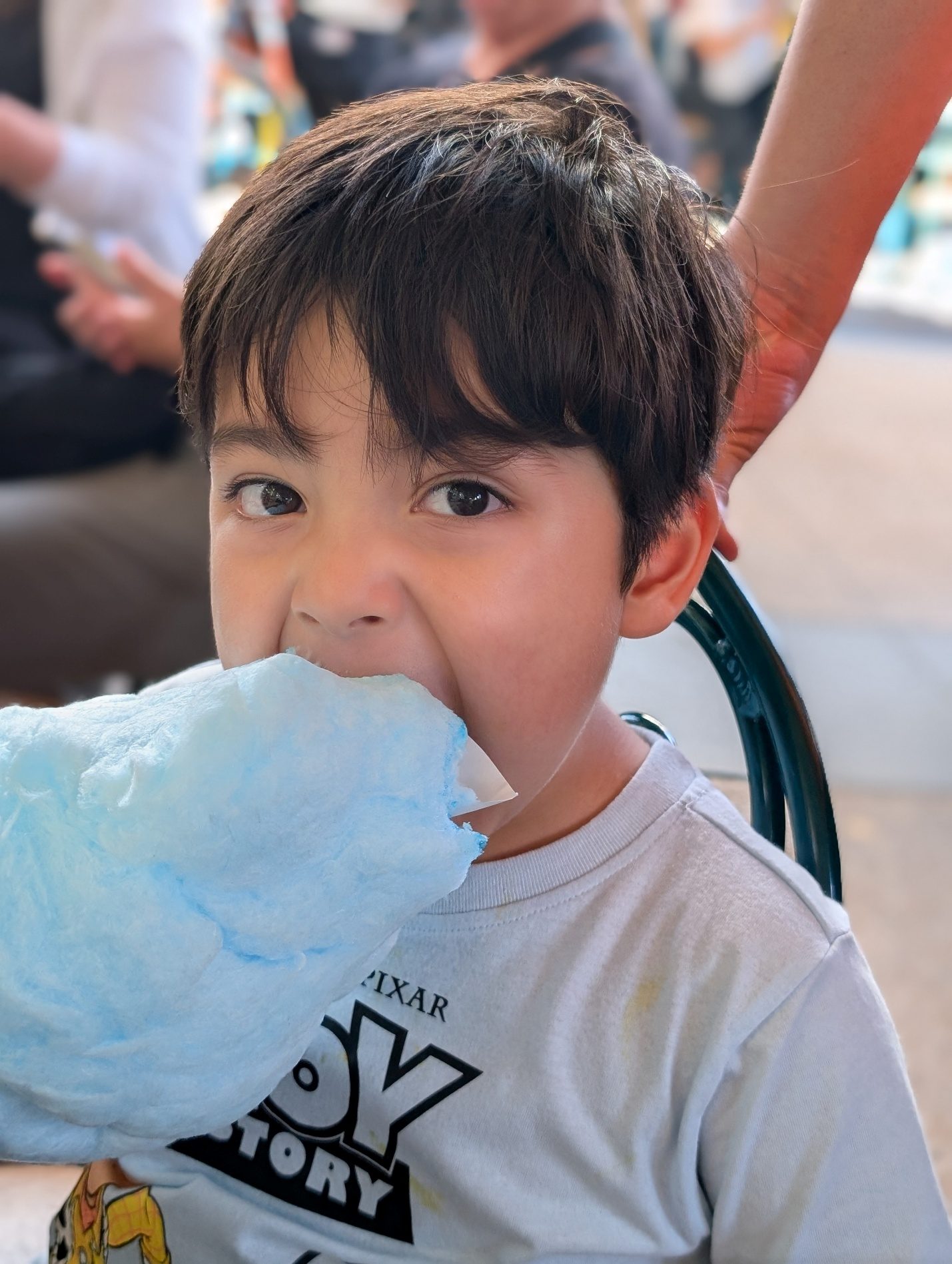 Child eating blue cotton candy.