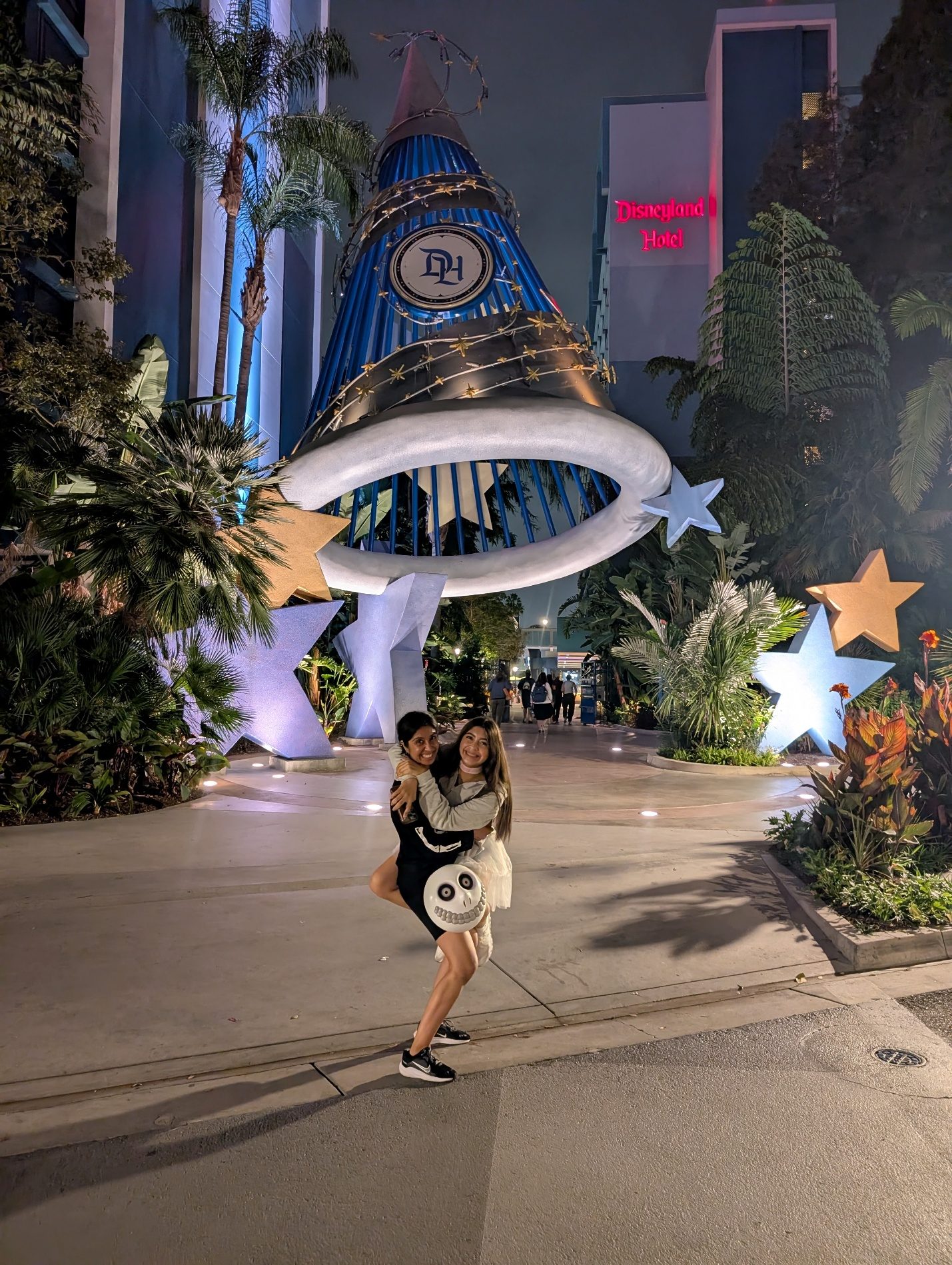 Mother and daughter posing near a fountain at night.