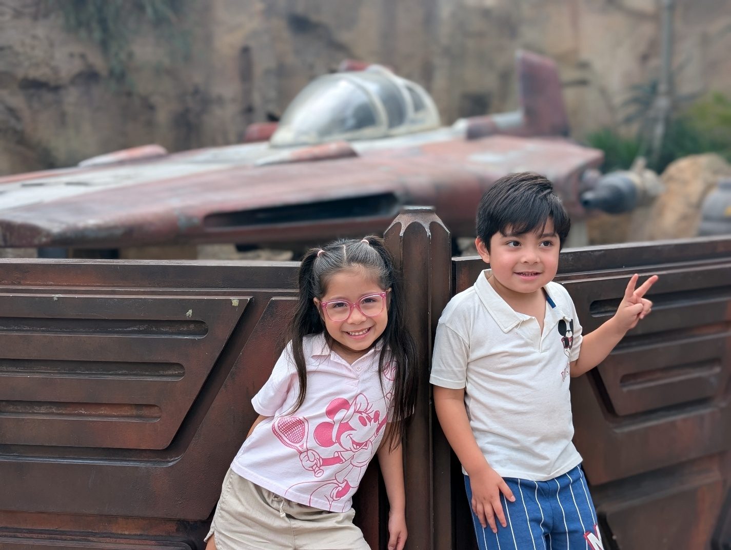Children posing beside a Star Wars landspeeder.