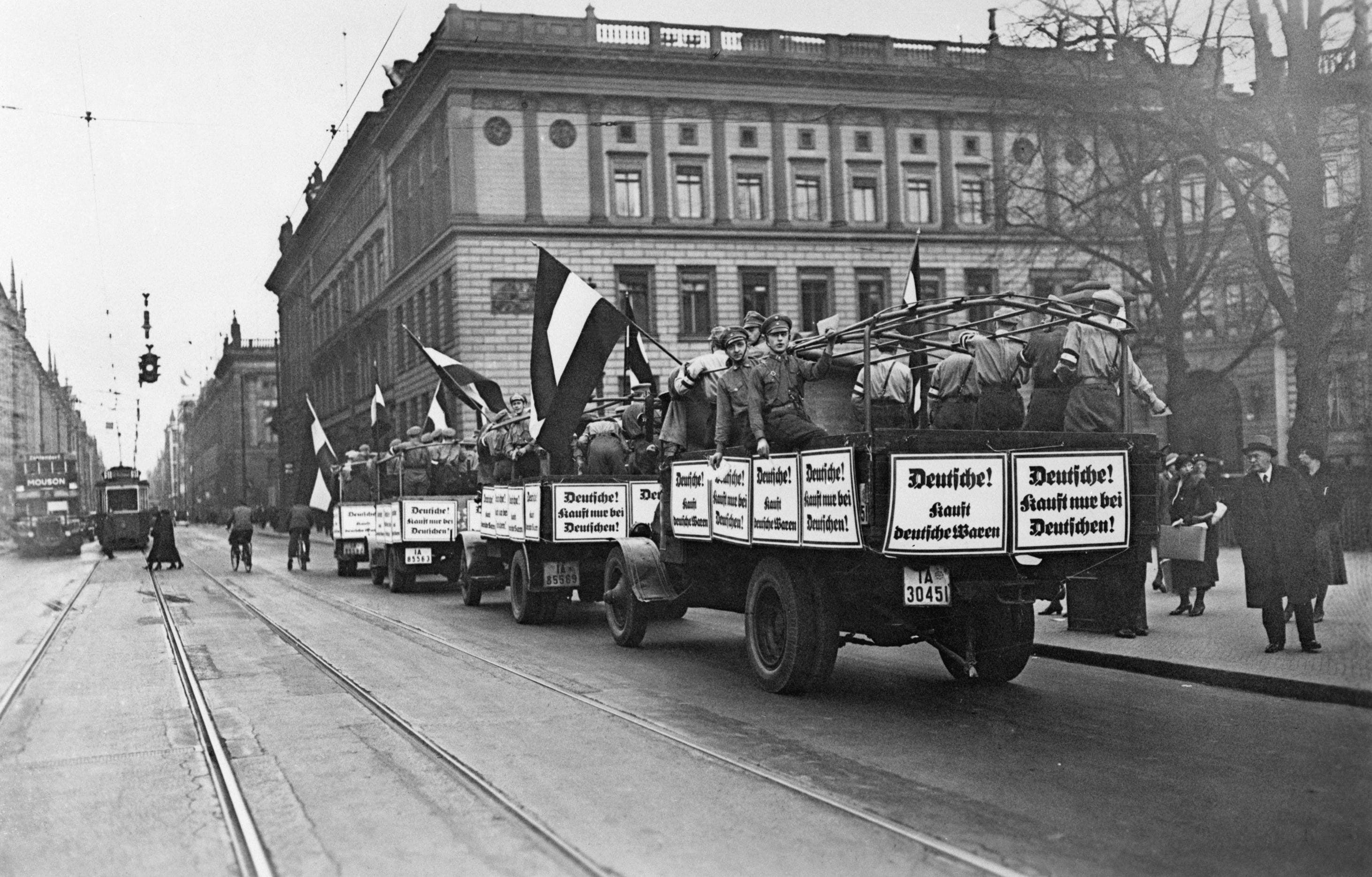 Nazi propaganda trucks with anti-Jewish boycott signs driving through Berlin in 1933.