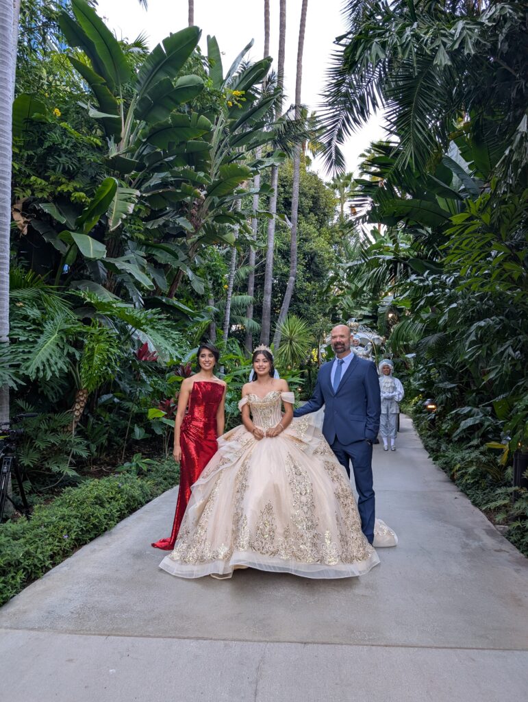 A family posing with their daughter in her quinceanera dress at Disneyland.